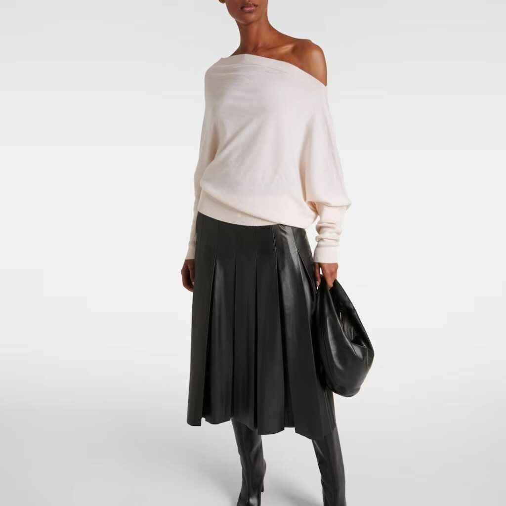 Model wearing cashmere hip-length sweater styled with tailored dress
