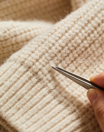 Use tweezers to remove the tiny lint balls from the plush sweater